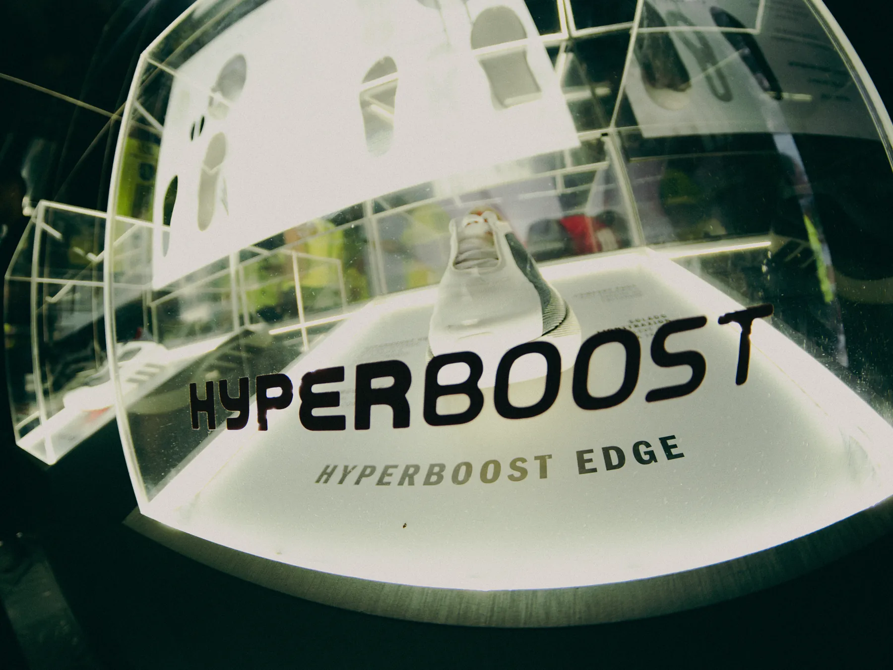 Expositor Hyperboost Edge com tênis em vitrine de acrílico