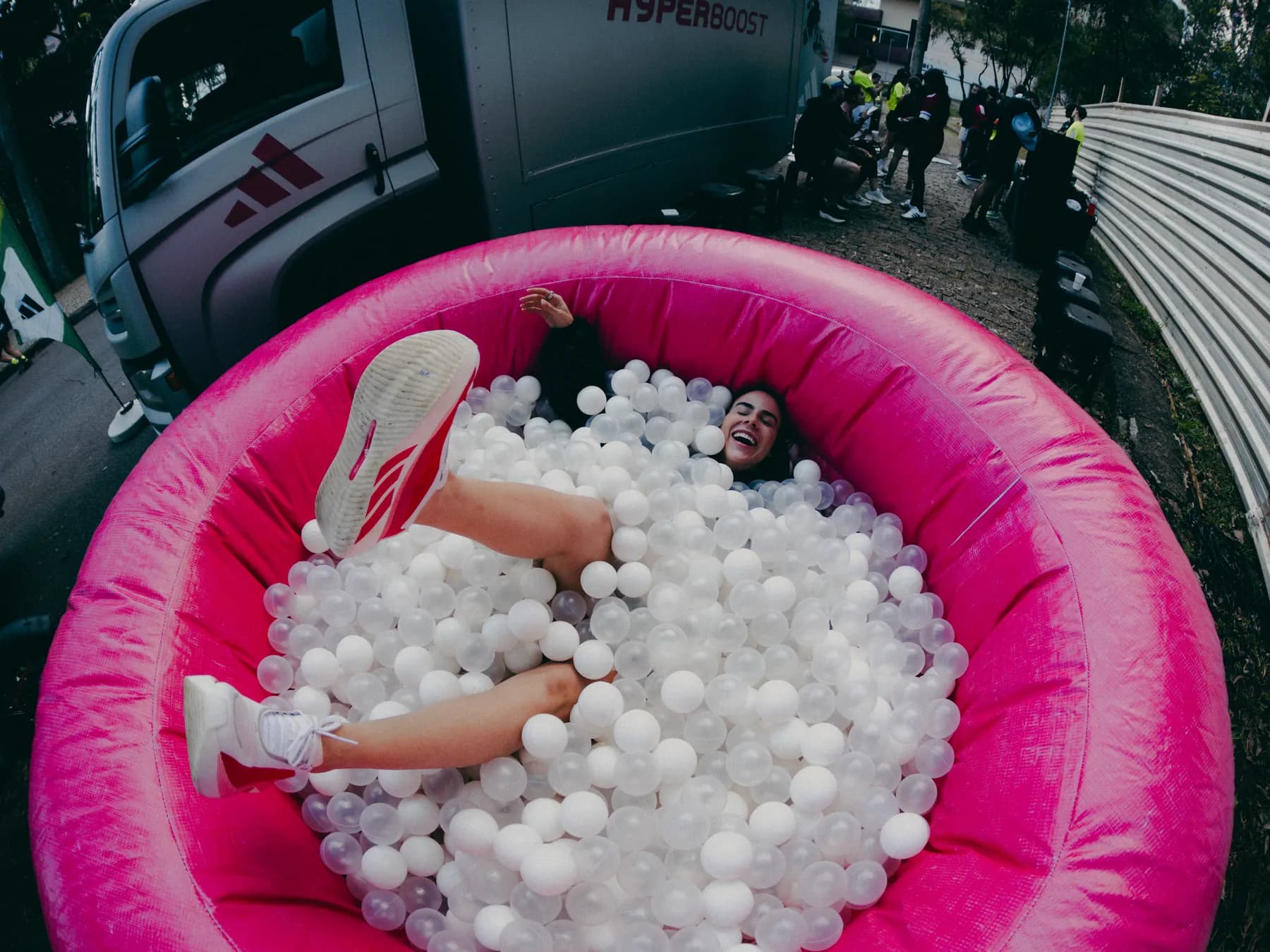 Mulher deitada na piscina de bolinhas da ativação Hyperboost, vista de cima