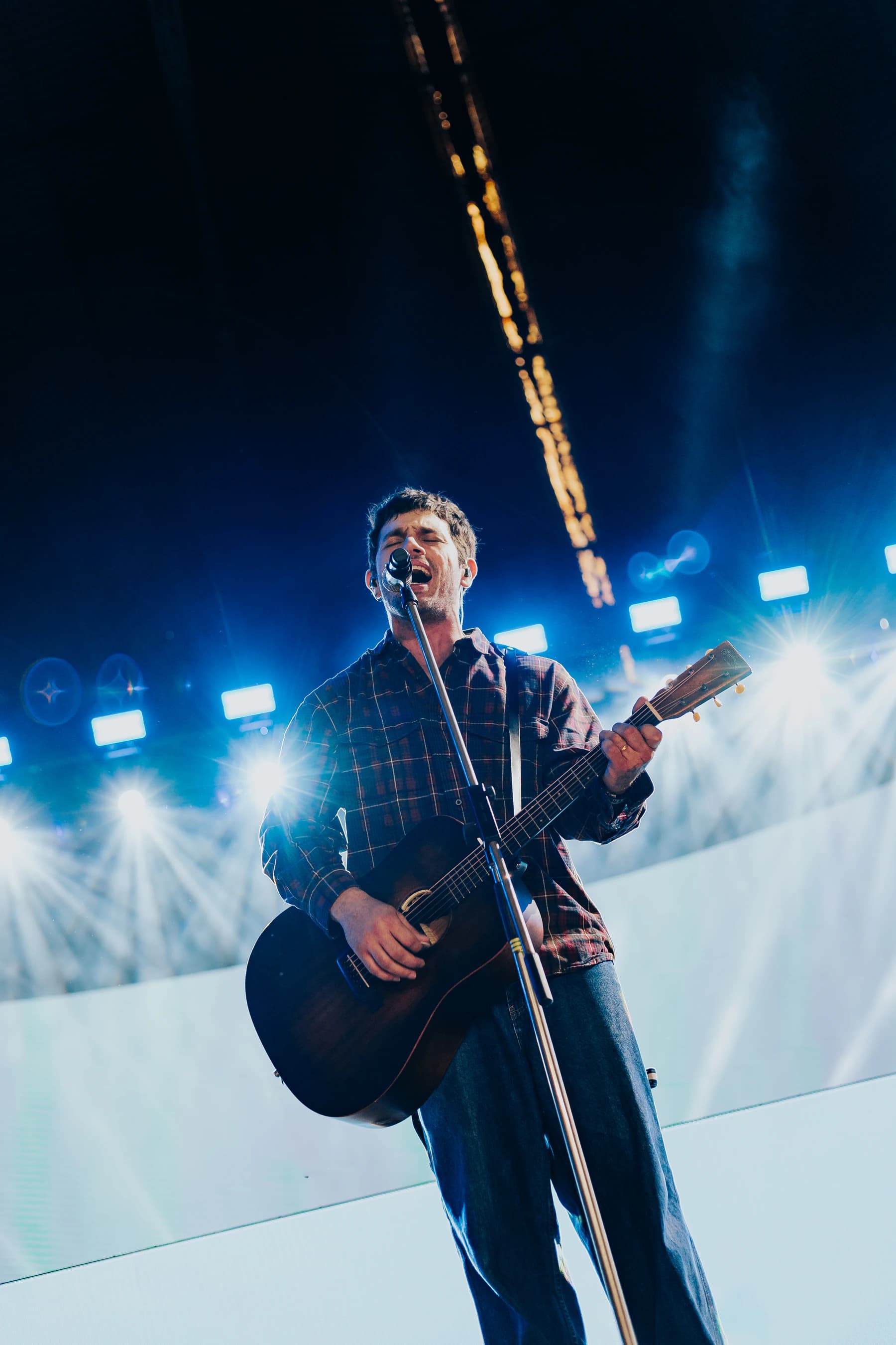 Cantor em palco em uma foto finalizada por Lucas Raw